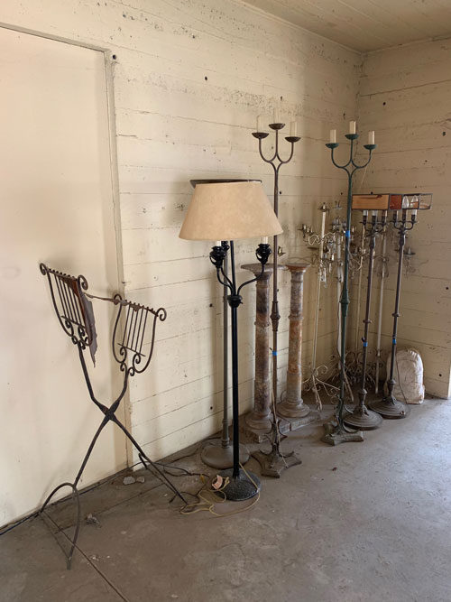 [Concrete wall lined with various
kinds of electric lamp, mostly in the shape of tall candelabras; on the left, a
music stand in a form representing a lyre.]